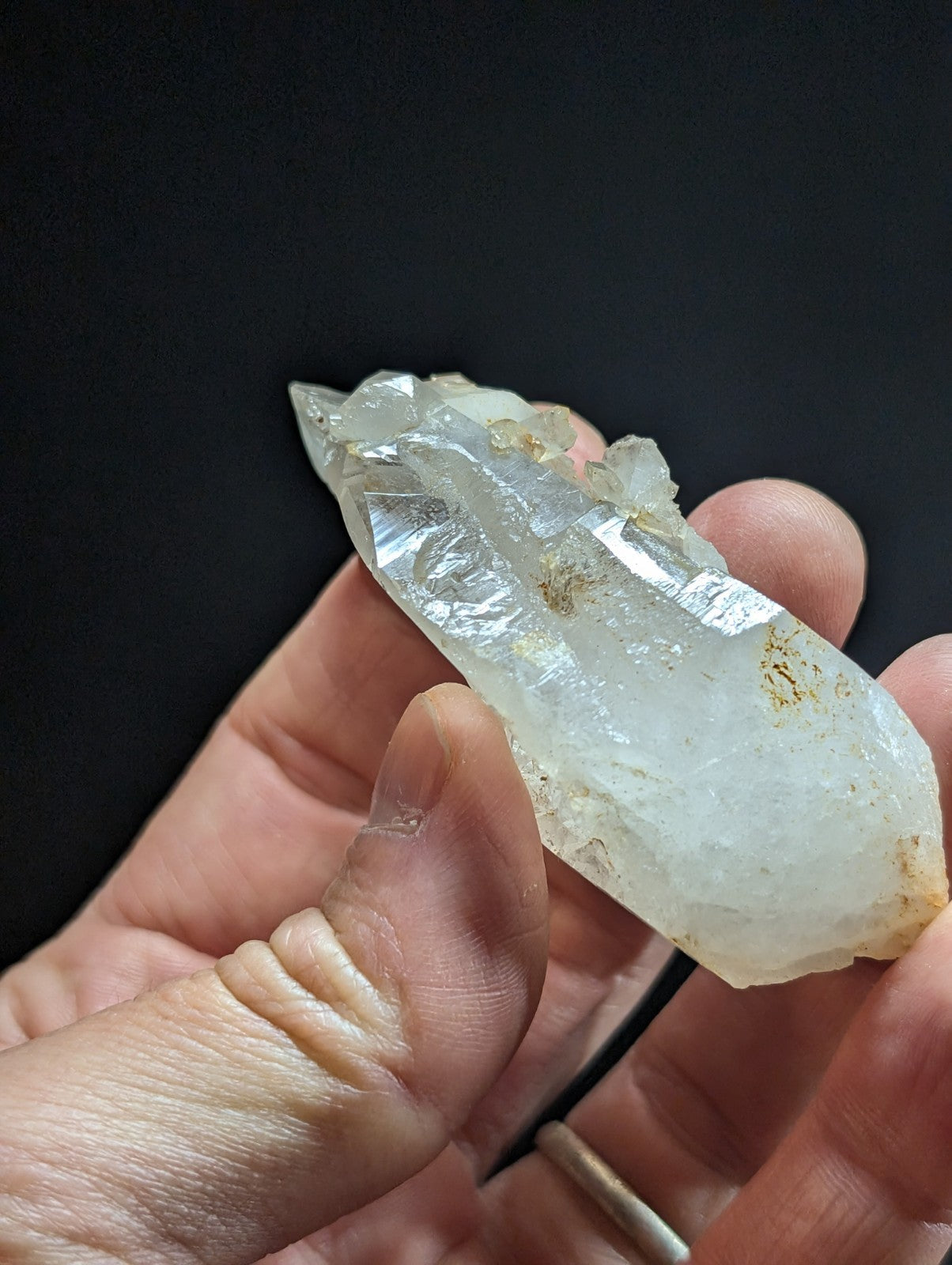 A translucent, pale quartz crystal with natural facets and subtle golden inclusions.