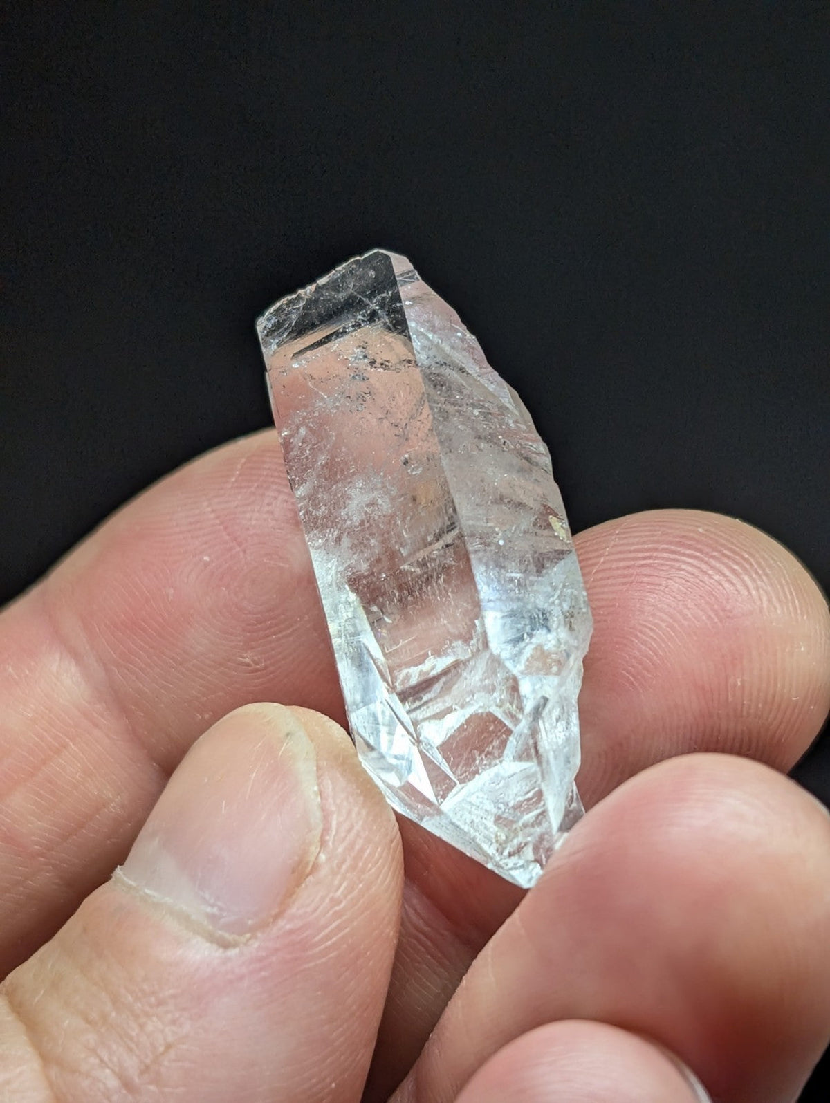 A translucent, clear quartz crystal with natural facets and internal inclusions.