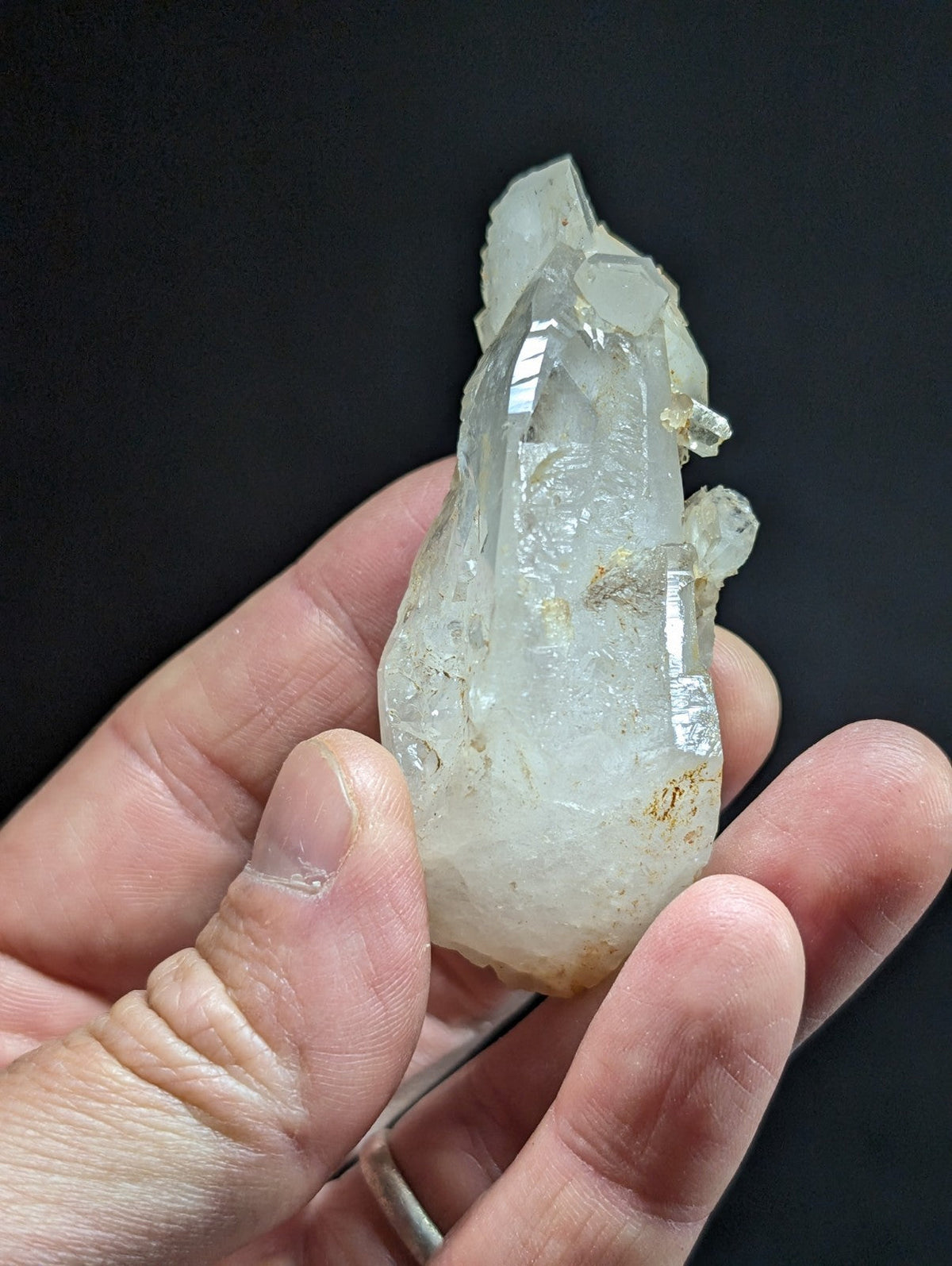 A translucent, clear quartz crystal with a pointed tip and natural facets.