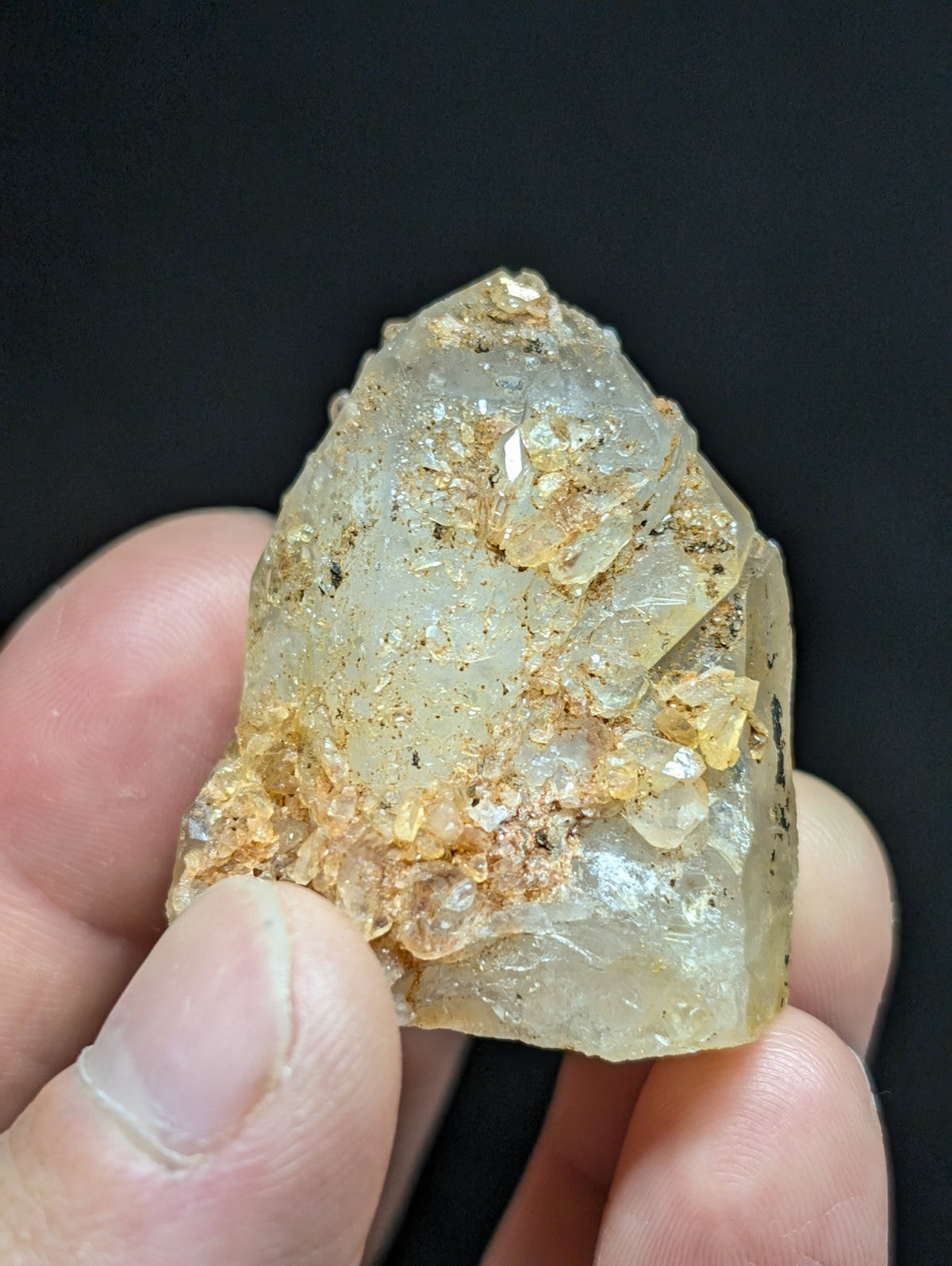 A translucent, pale quartz crystal specimen with golden mineral inclusions and rough, natural edges.