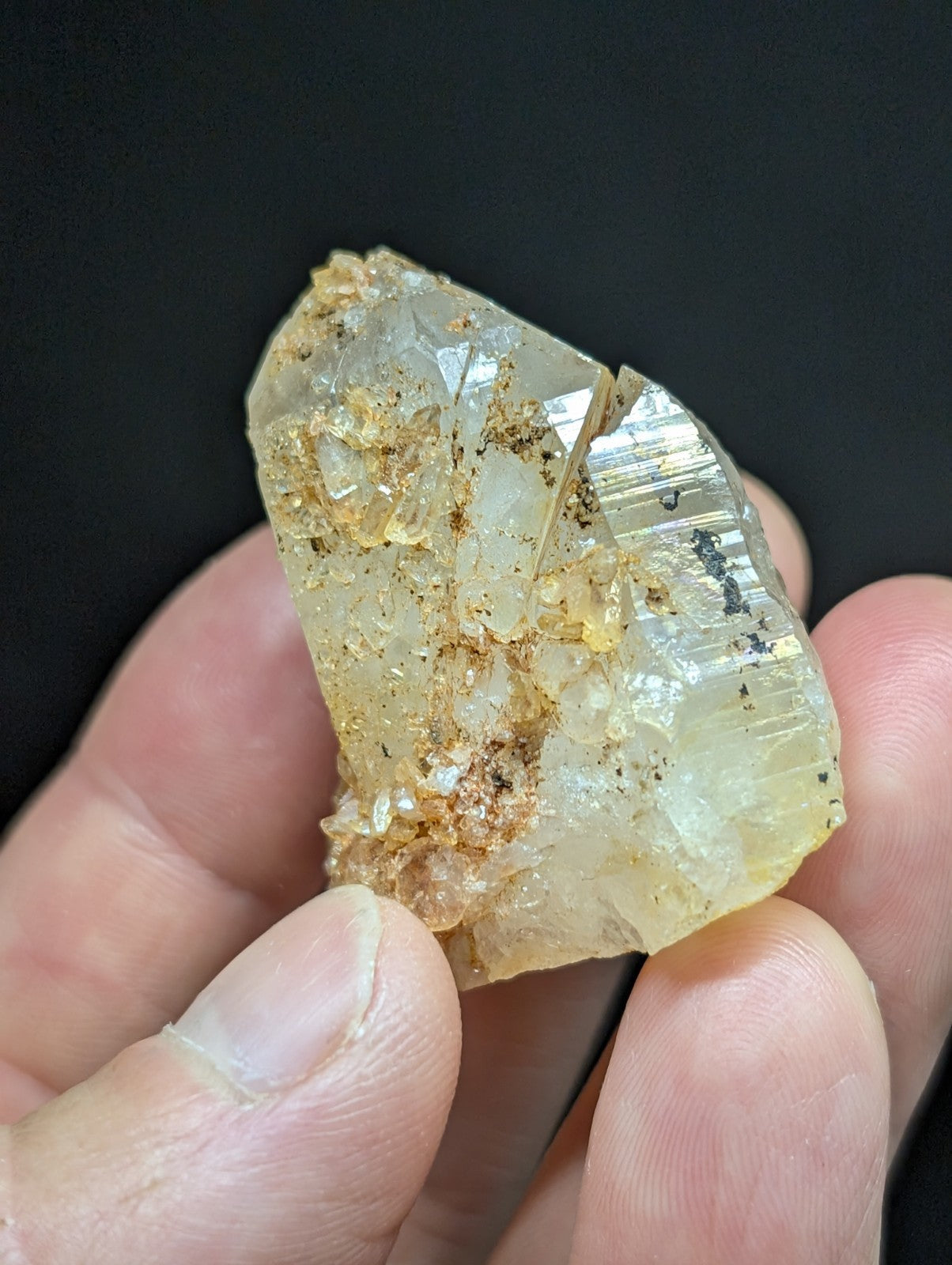 A translucent, pale yellow quartz crystal with visible internal striations and golden-brown mineral inclusions.