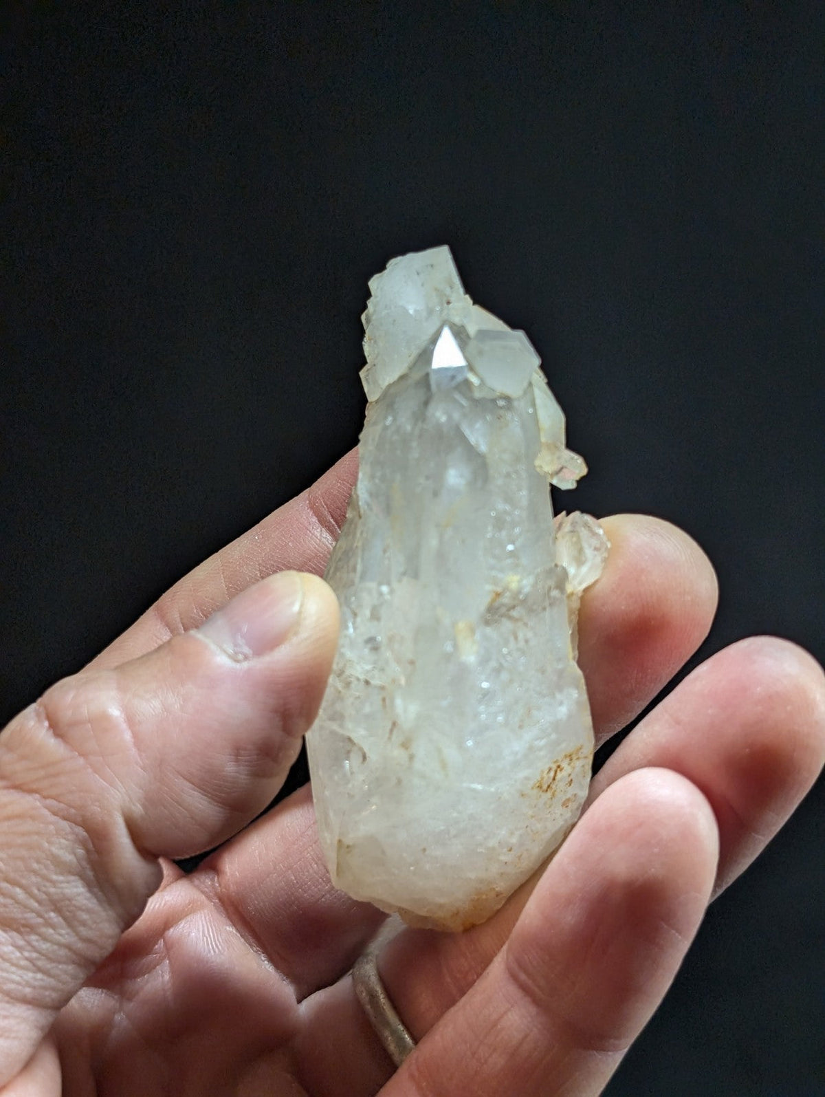 A translucent, pale quartz crystal with a pointed tip and natural facets.