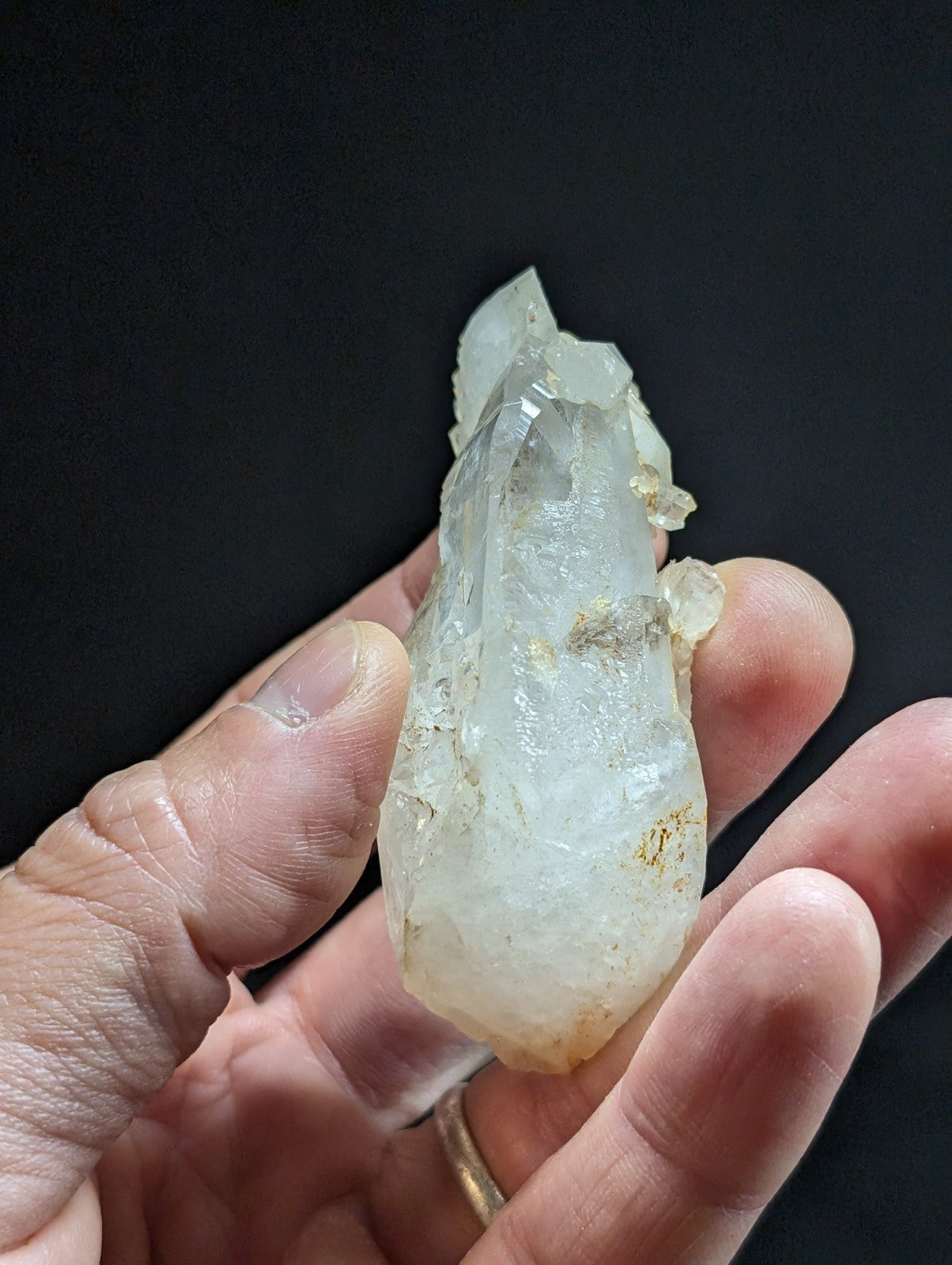 A translucent, pale quartz crystal with a pointed tip and natural imperfections.
