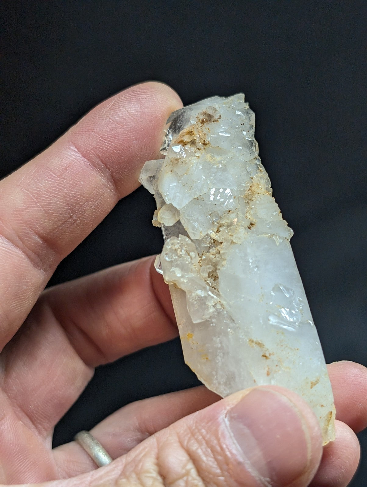 A translucent white quartz crystal cluster with natural imperfections and earthy brown inclusions.