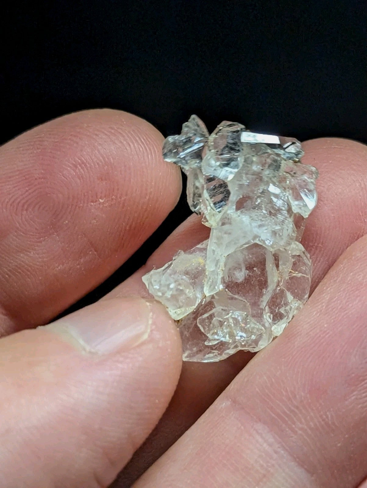 A translucent, clear quartz crystal cluster with jagged edges and a slightly greenish tint.