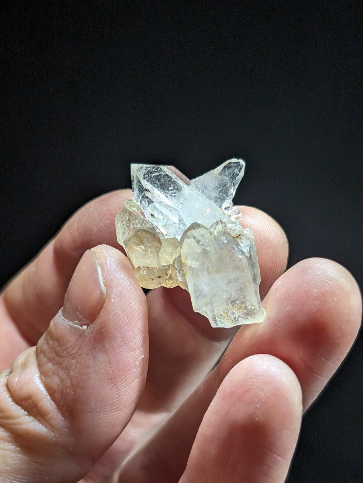 A translucent, pale yellowish-white quartz crystal cluster with sharp, angular facets and a natural, irregular growth pattern.