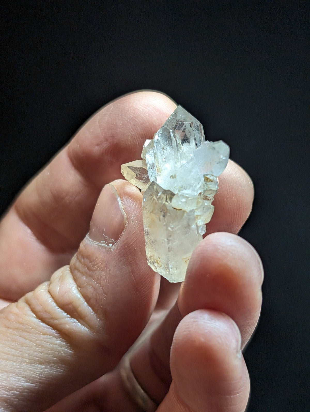A translucent, pale quartz crystal cluster with sharp facets and a slightly cloudy base.