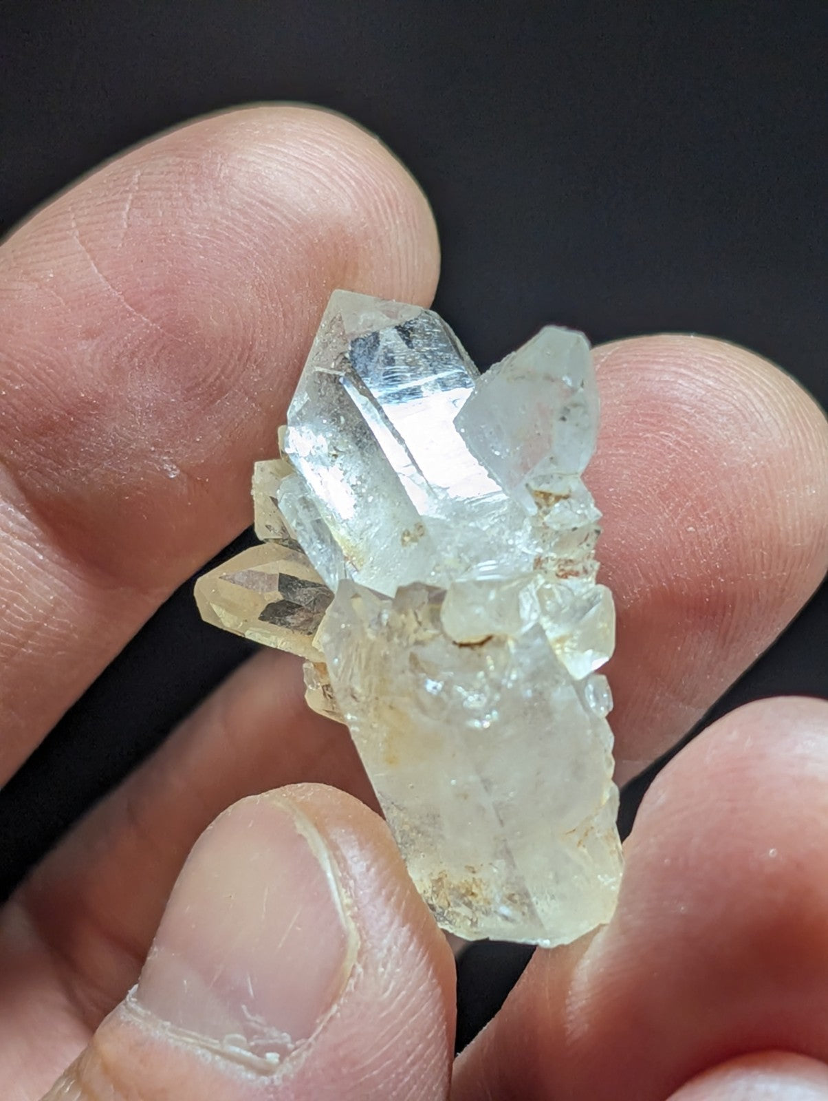 A translucent, pale quartz crystal cluster with sharp facets and a slightly yellowish tint.