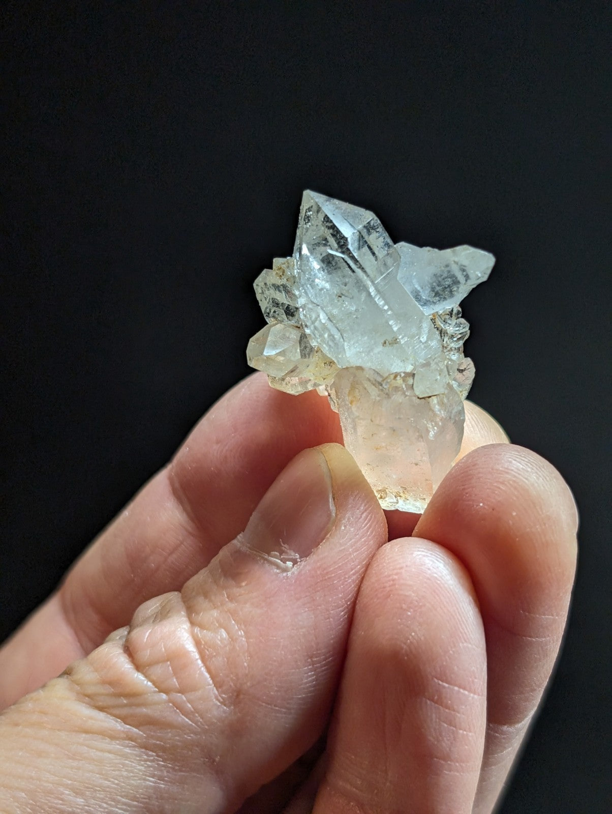A translucent, pale blue-green quartz crystal cluster with sharp facets and a slightly cloudy base.