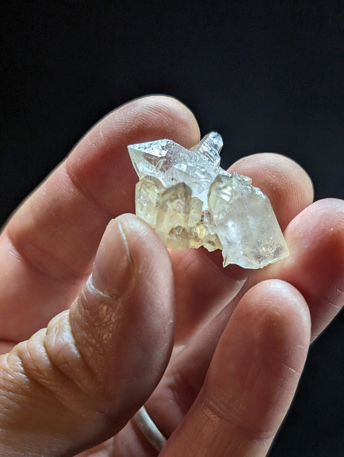 A translucent, crystalline mineral cluster with sharp facets and a pale yellowish hue.