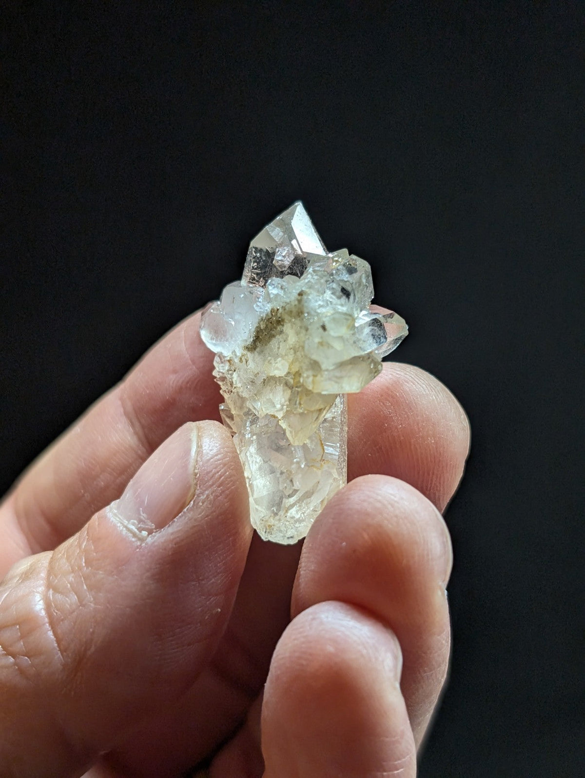A translucent, pale quartz crystal cluster with sharp facets and a slightly cloudy base.
