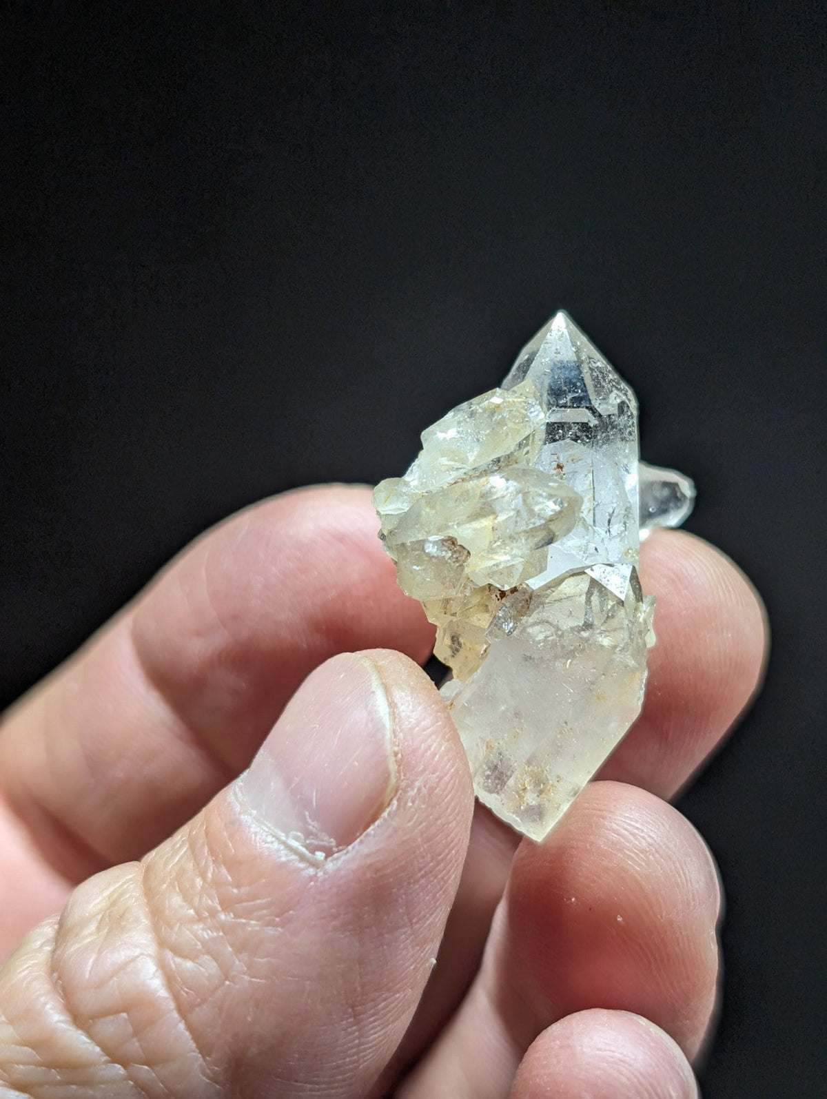 A translucent, pale yellow quartz crystal cluster with sharp geometric facets and a slightly cloudy base.
