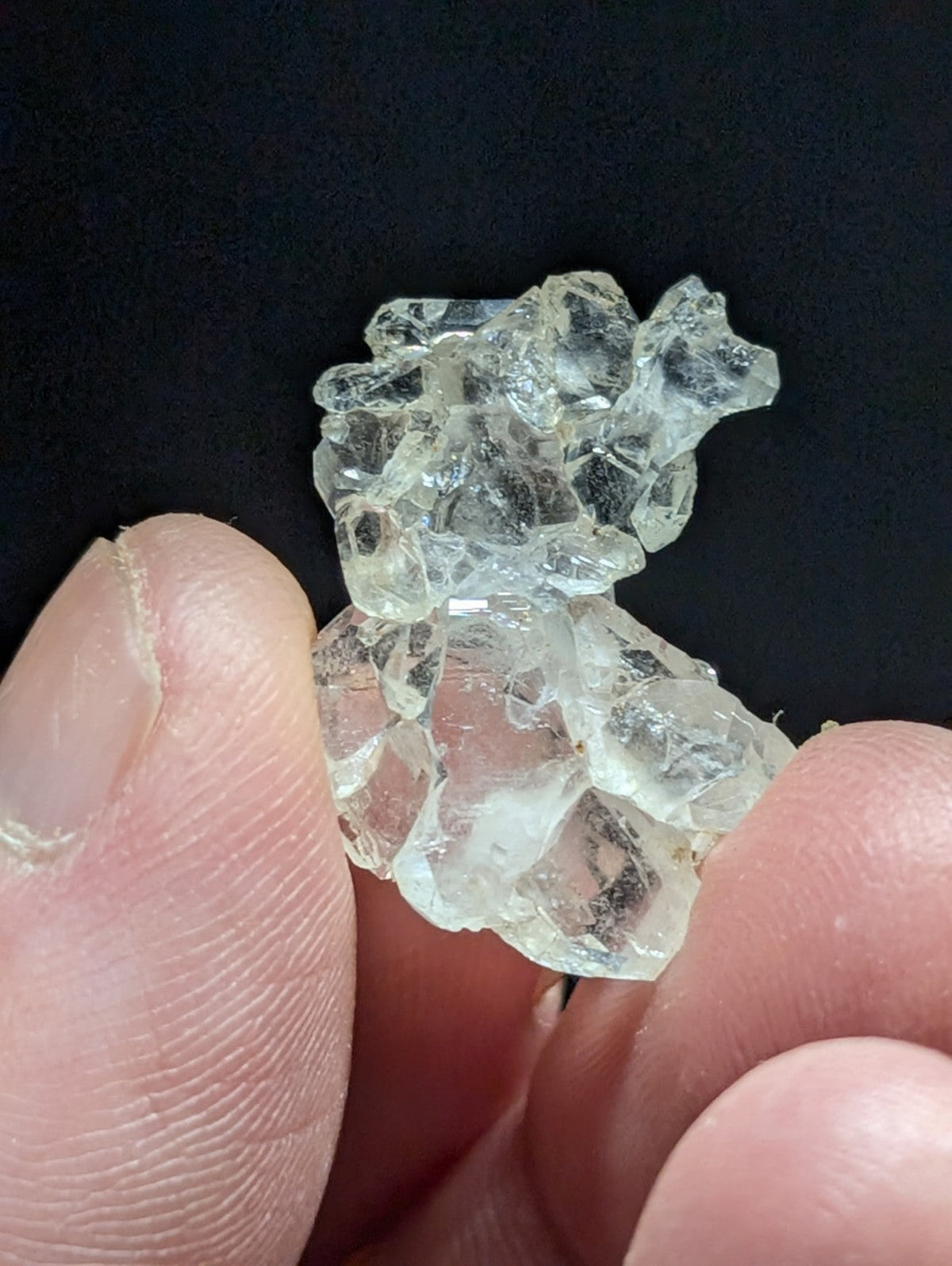 A cluster of clear, translucent quartz crystals with jagged edges and a glassy sheen.