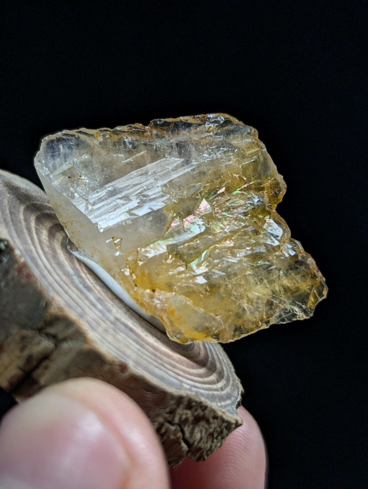 A translucent yellow crystal with visible internal striations and a rough, jagged surface.