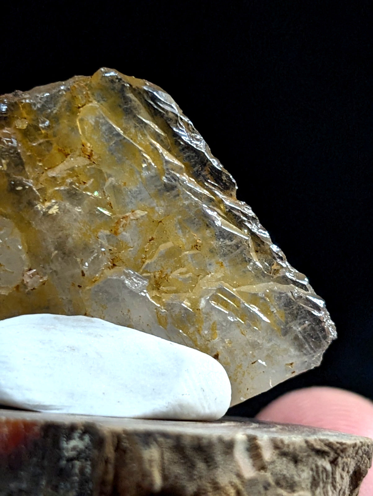 A translucent yellowish crystal with a rough, jagged surface and visible internal inclusions.