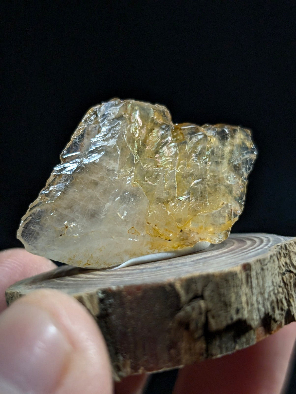 A translucent yellowish crystal with a rough, jagged surface and internal crystalline structures.