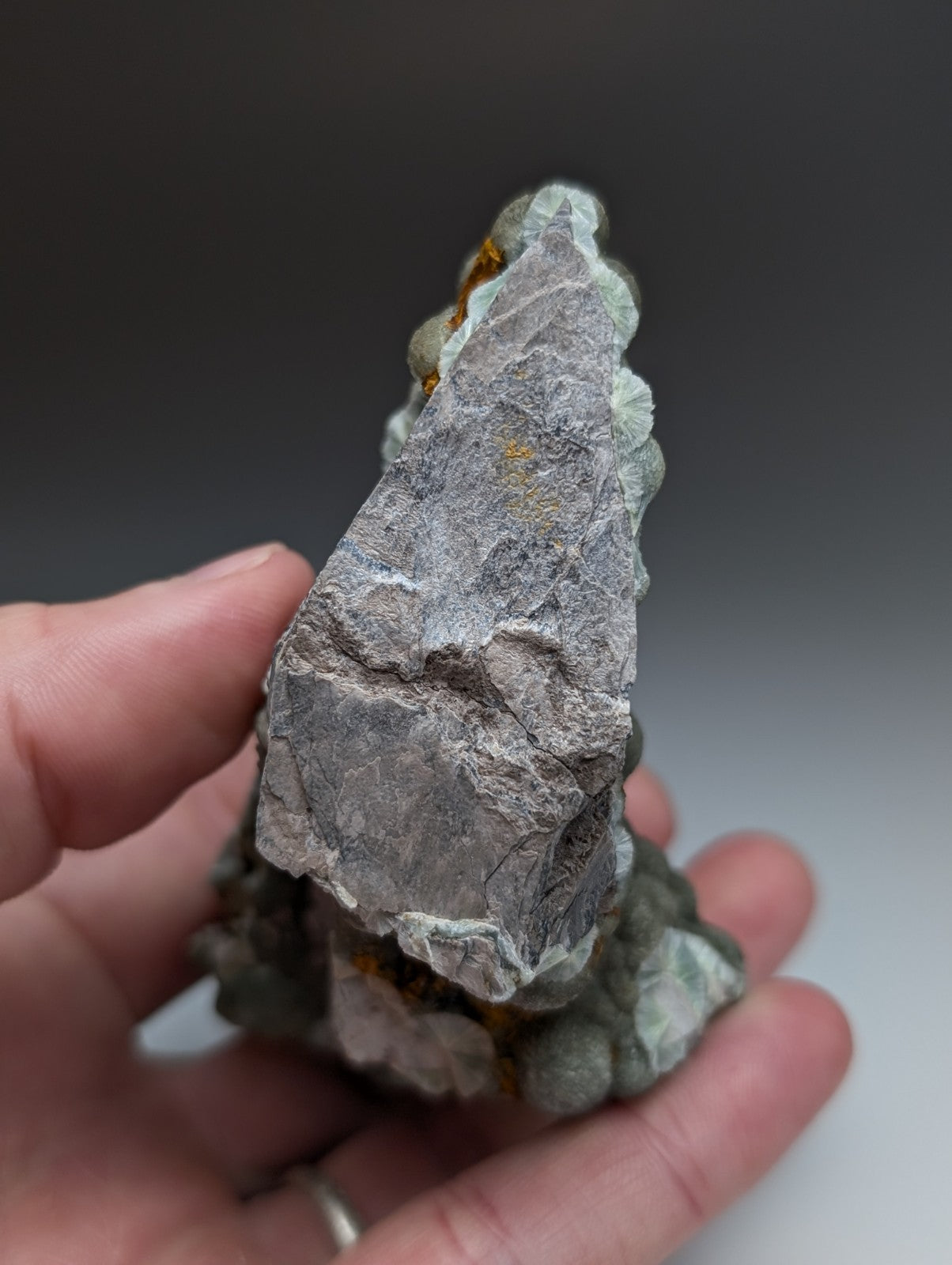 Uv reactive green wavellite cluster with gray jagged mineral and small orange inclusions from mauldin mountain arkansas usa