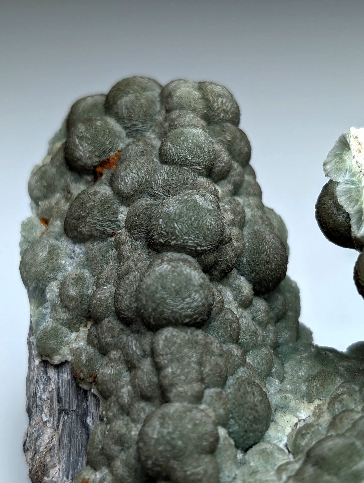 Uv reactive green wavellite cluster with dark green rounded mineral formations and a bumpy surface from mauldin mountain arkansas usa