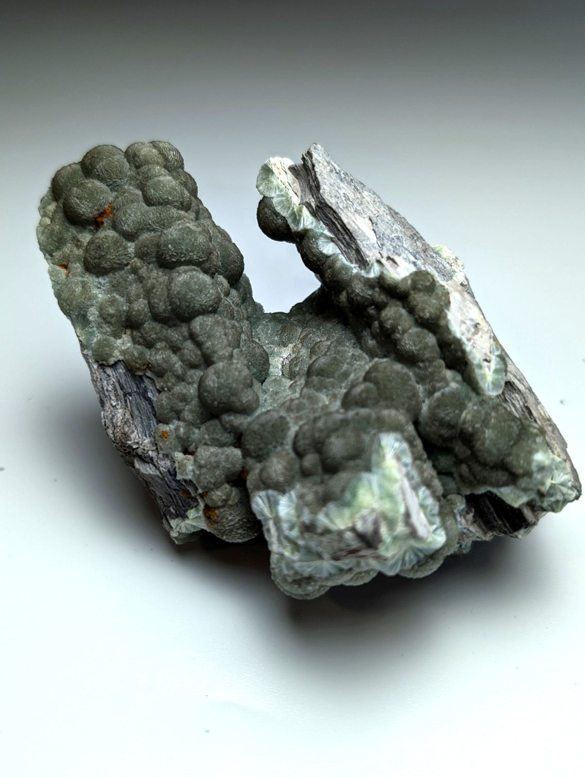 Uv reactive green wavellite cluster with textured greenish gray surface and translucent crystals from mauldin mountain arkansas