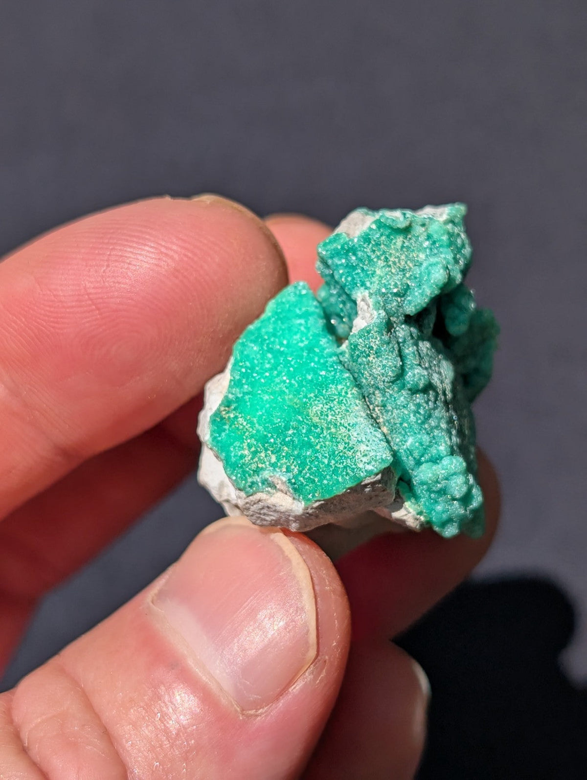 A vibrant turquoise mineral specimen with a rough, crystalline texture and white matrix.