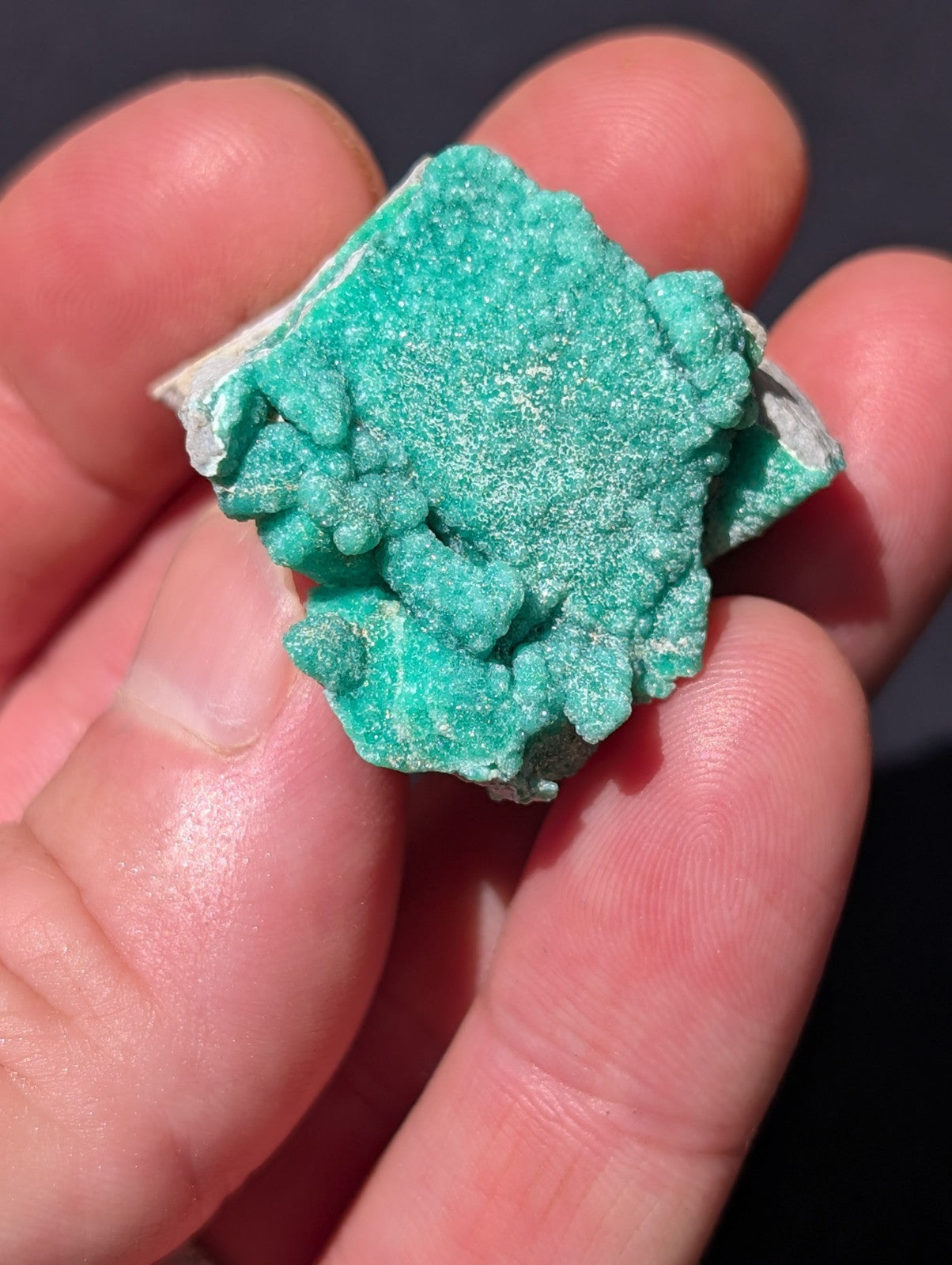 A vibrant turquoise mineral specimen with a rough, crystalline texture and jagged edges.