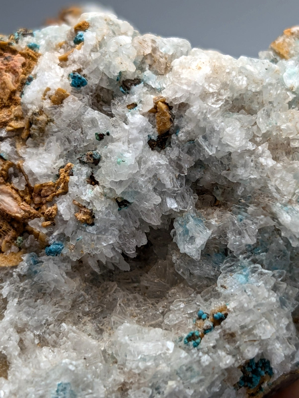 A translucent white selenite crystal with blue aurichalcite and brown inclusions from red cloud mine arkansas
