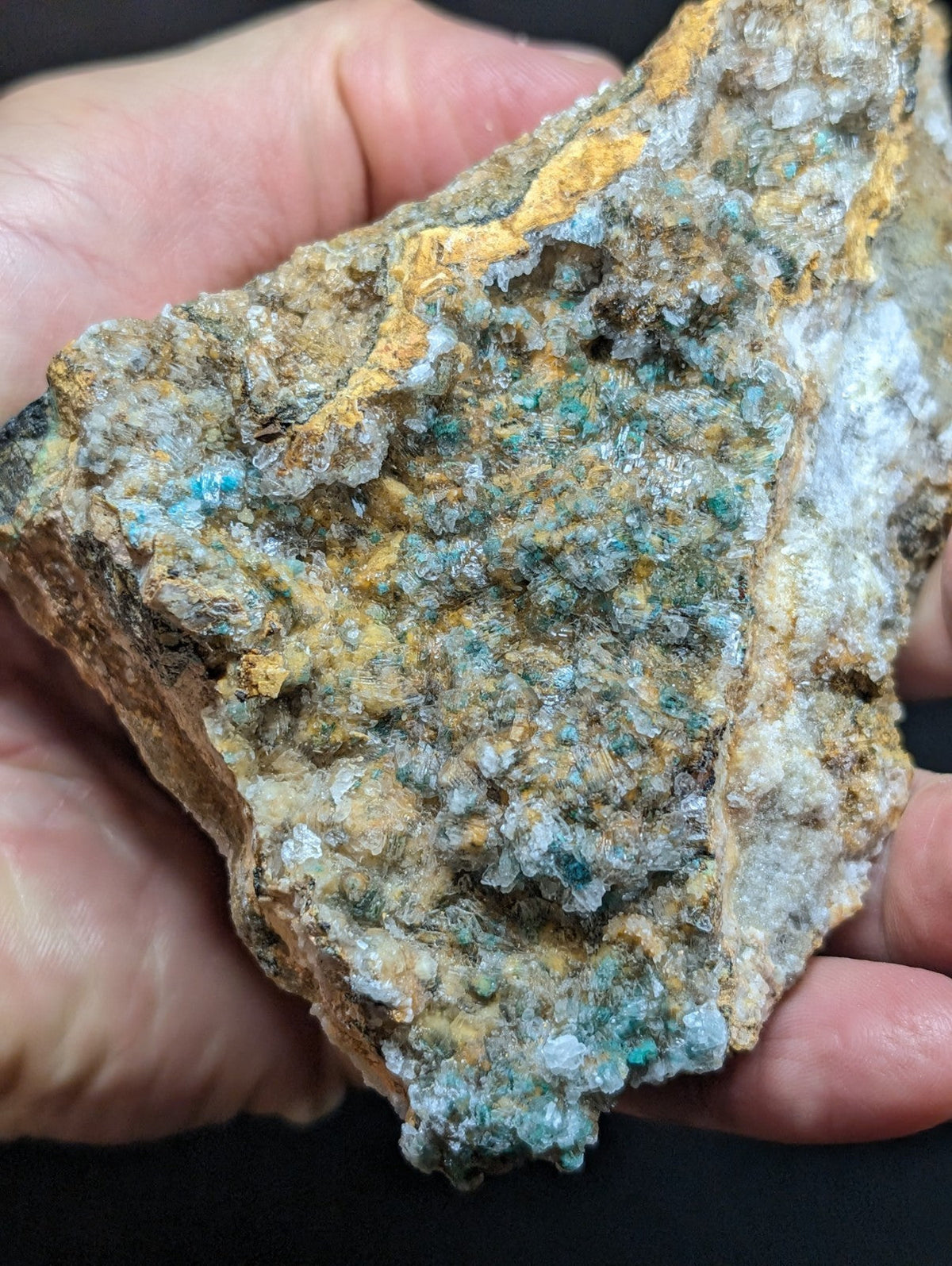 A rugged, irregularly shaped mineral specimen featuring vibrant turquoise crystals embedded in a matrix of earthy yellow and gray rock.