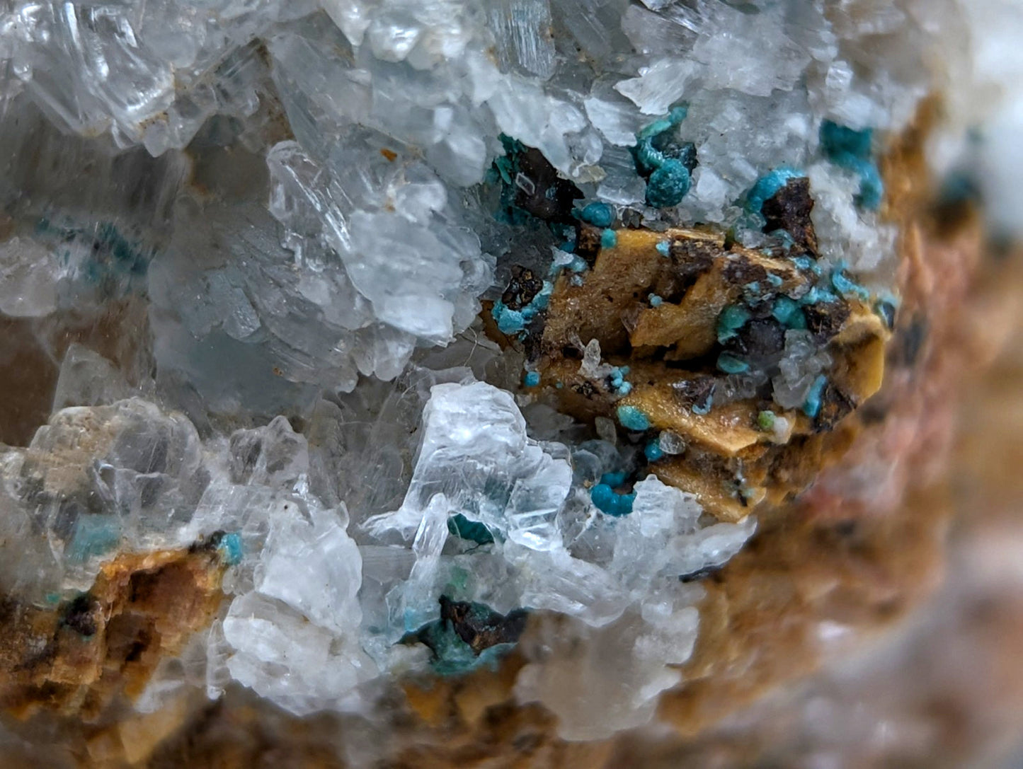 A cluster of translucent quartz with vibrant turquoise aurichalcite and earthy brown selenite from red cloud mine arkansas