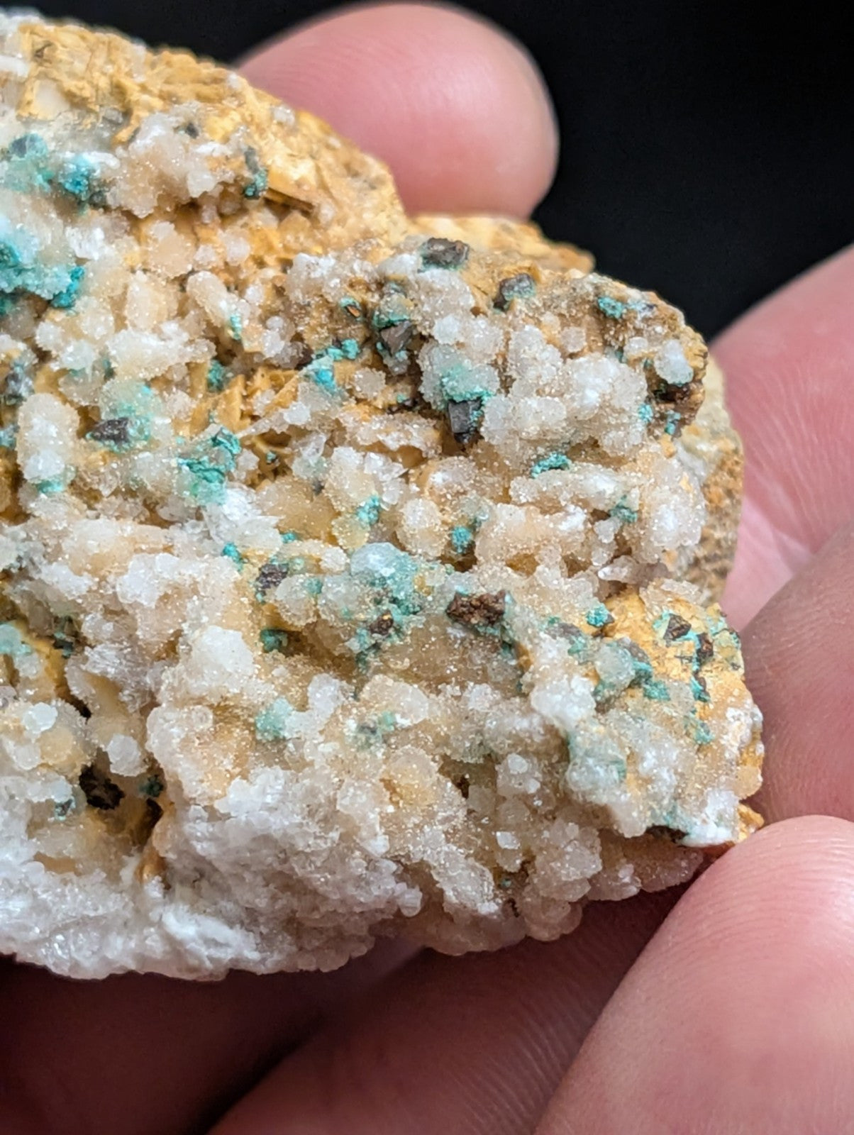 A textured mineral specimen featuring a mix of white, yellowish-orange, and vibrant turquoise crystalline formations.