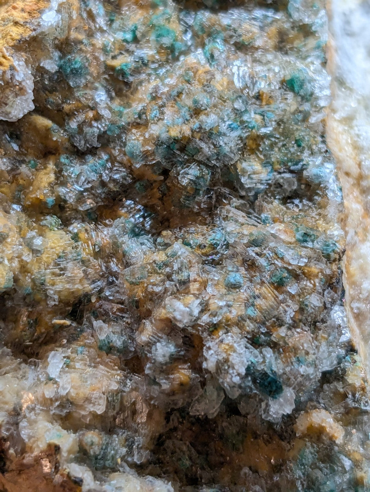 A cluster of translucent green and yellow mineral crystals with a rough, jagged surface.