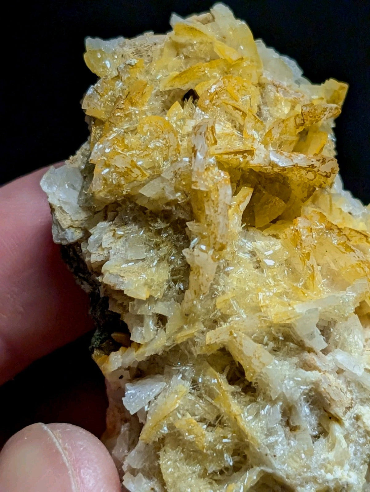 A cluster of translucent yellow and white crystals with sharp, jagged edges.