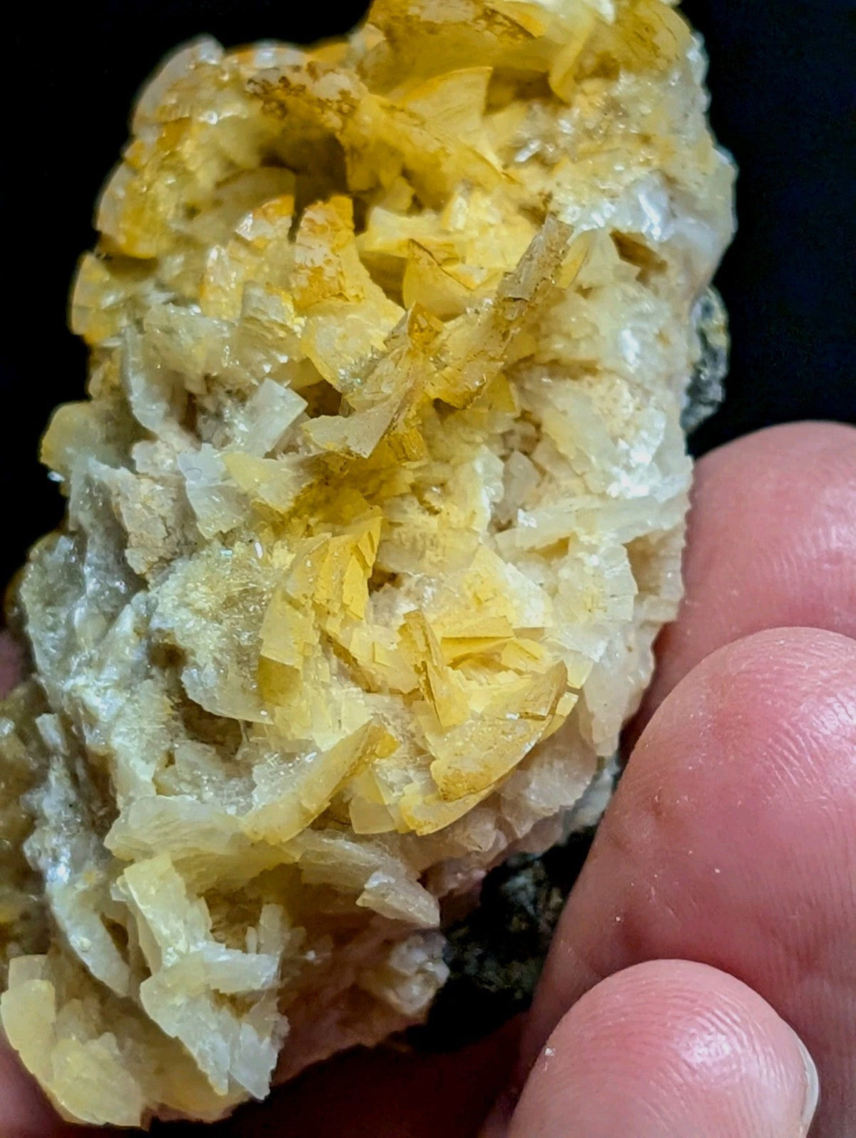 A cluster of translucent yellow and white crystals with sharp, angular facets.