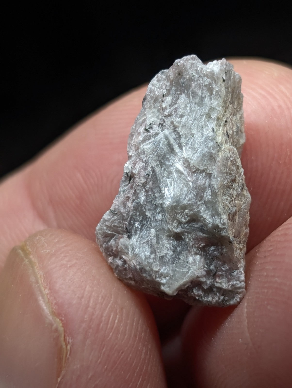 A rough, grayish-white mineral specimen with a crystalline texture and uneven edges.