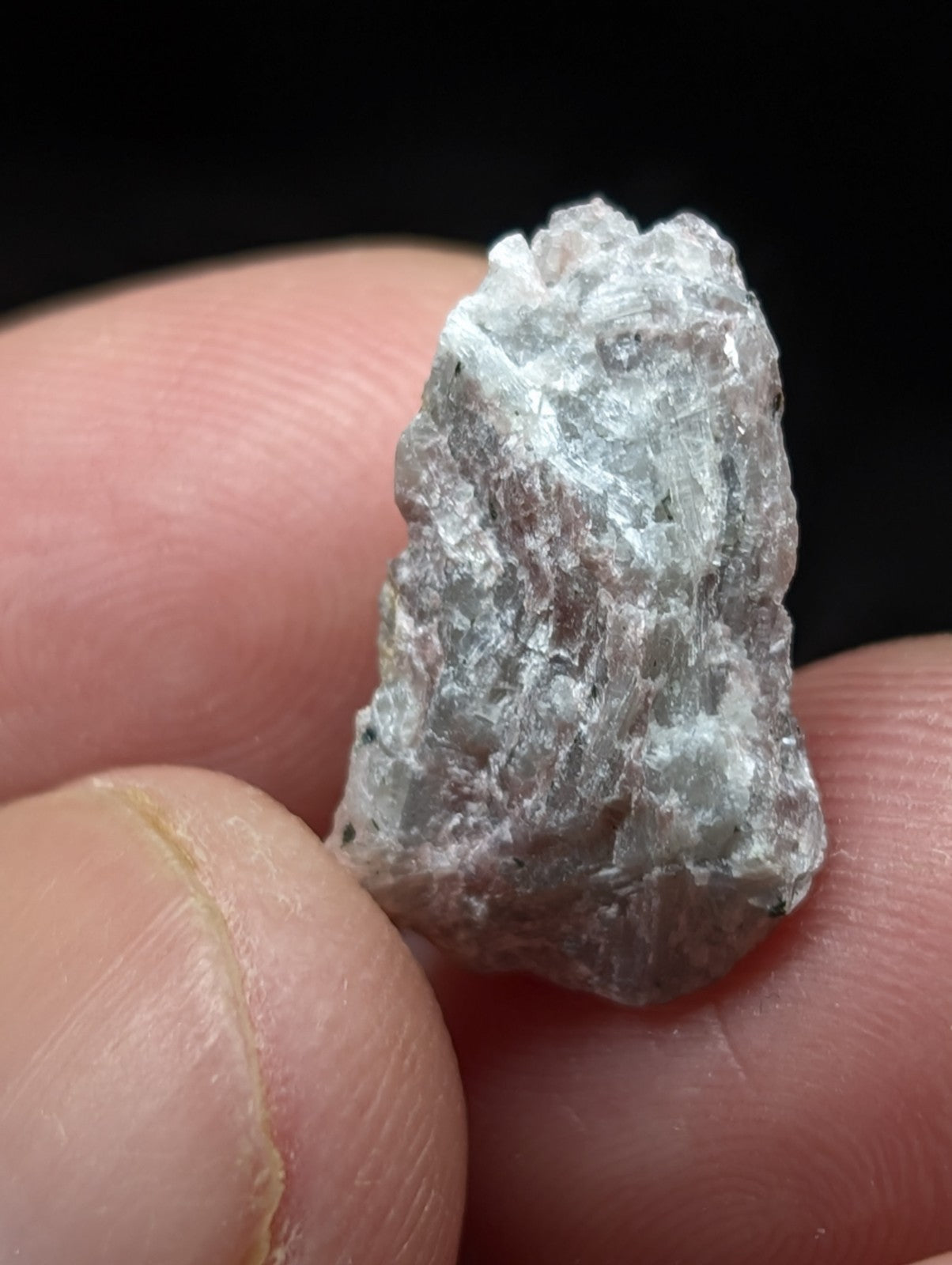 A rough, translucent light gray mineral specimen with a crystalline texture and visible internal inclusions.