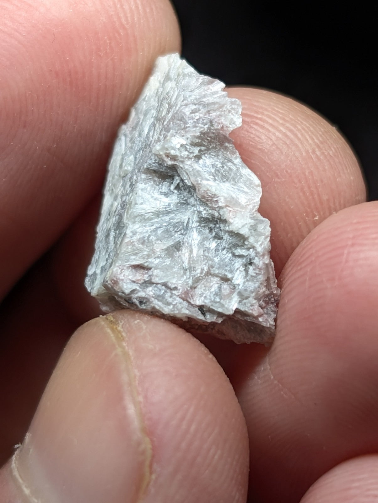 A rough, translucent gray mineral specimen with a crystalline texture and jagged edges.