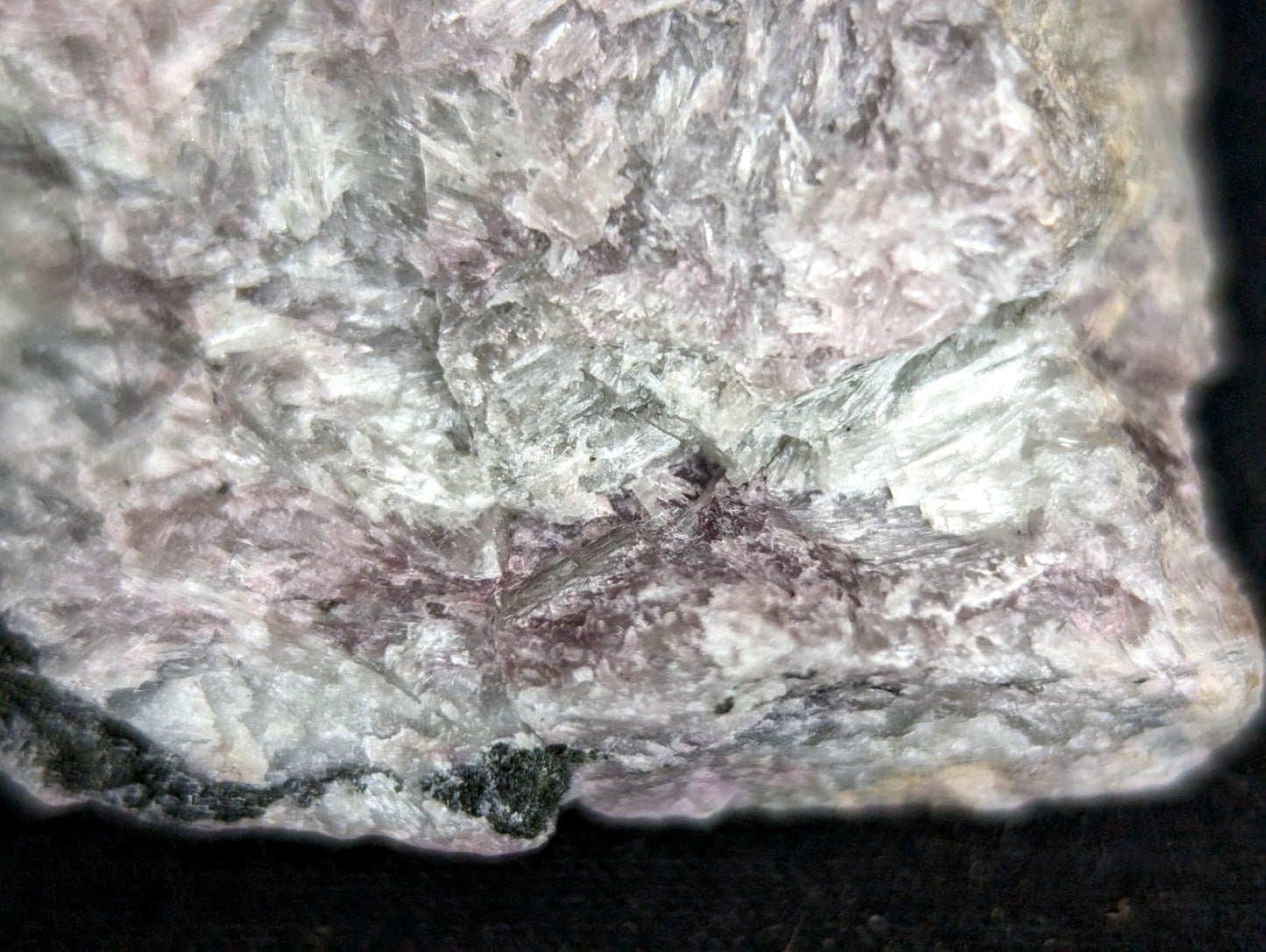 A rough, irregularly shaped rock with a mottled surface of pale pink and grayish-white mineral veins.