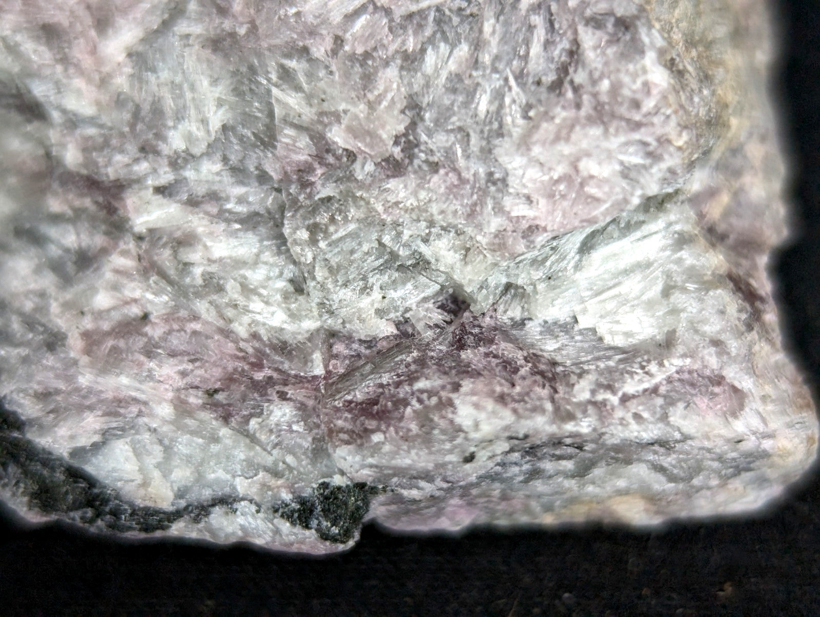 A rough, irregularly shaped rock with a mottled surface of pale pink and grayish-white mineral veins.