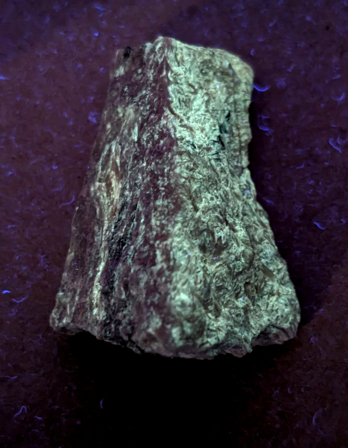 A rough, irregularly shaped mineral specimen with a mottled green and brown surface.