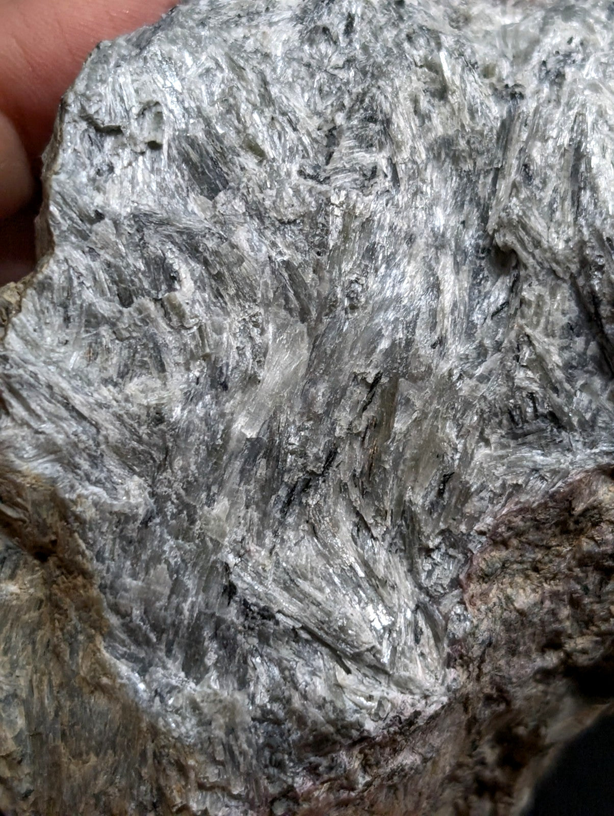 A rough, silver-gray mineral specimen with a crystalline texture and metallic sheen.