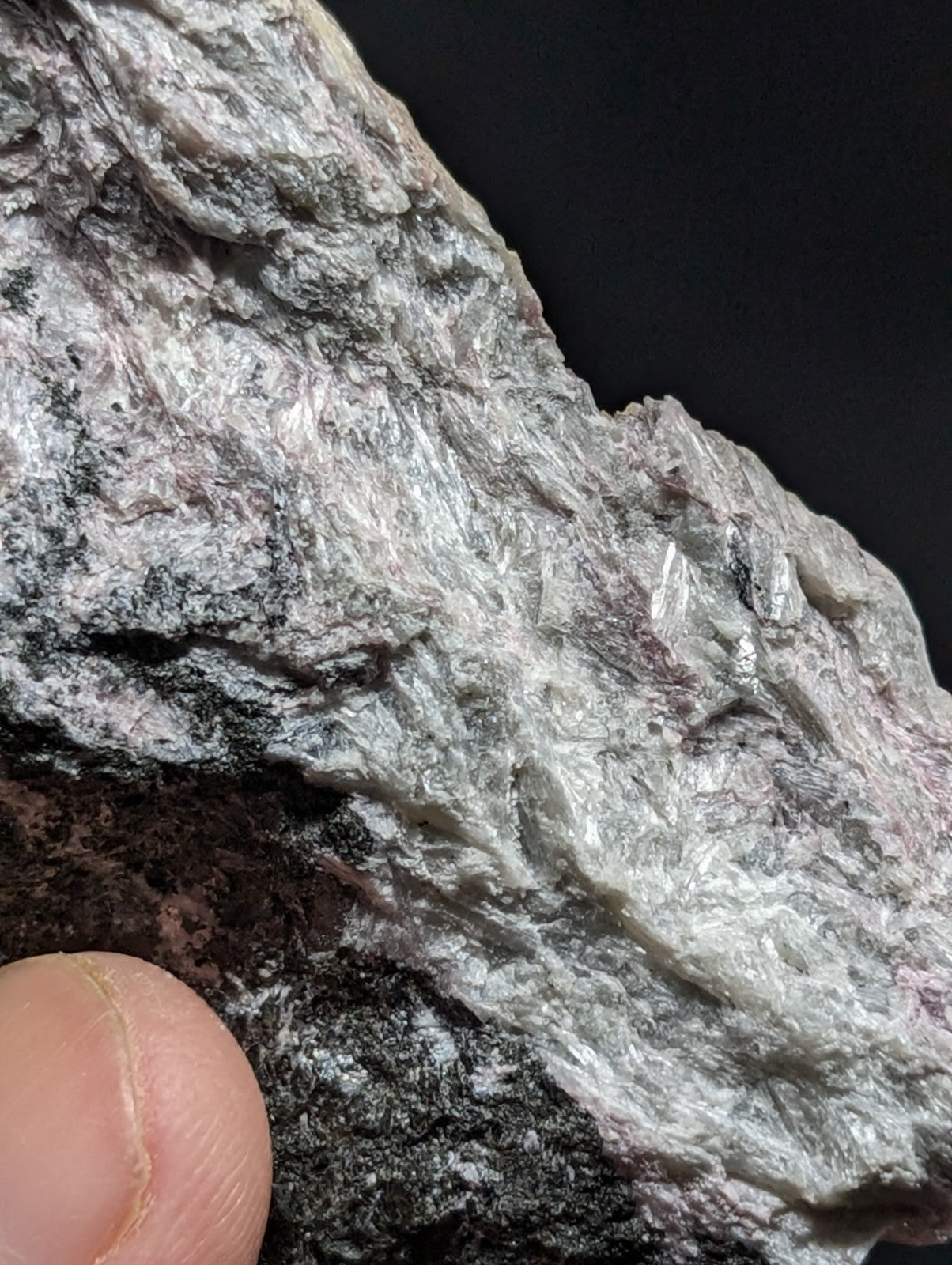A rough, grayish-white mineral specimen with a crystalline texture and subtle purple veining.