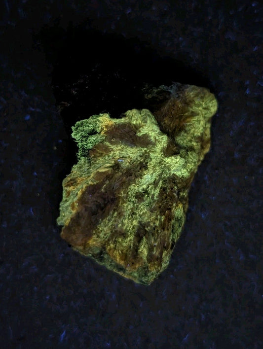 A rough, irregularly shaped rock with a mottled green and brown surface.