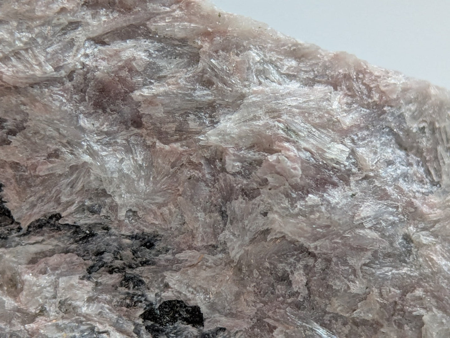 A translucent pink and white crystalline rock with a rough, jagged surface.
