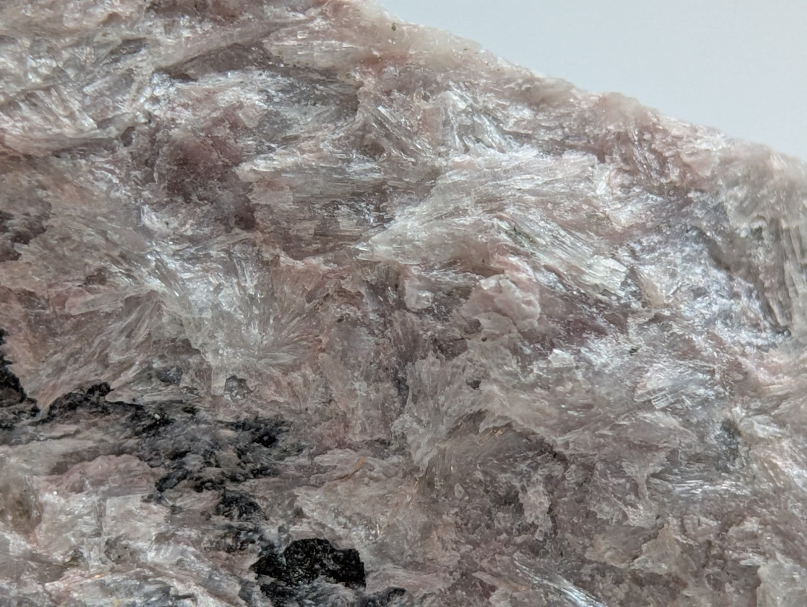 A translucent pink and white crystalline rock with a rough, jagged surface.