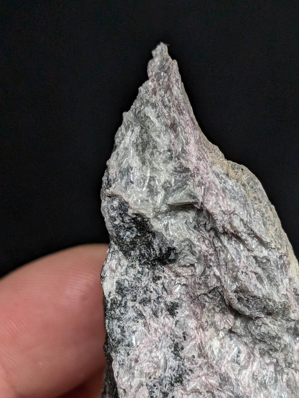 A rough, jagged rock specimen with a mottled gray and white surface.
