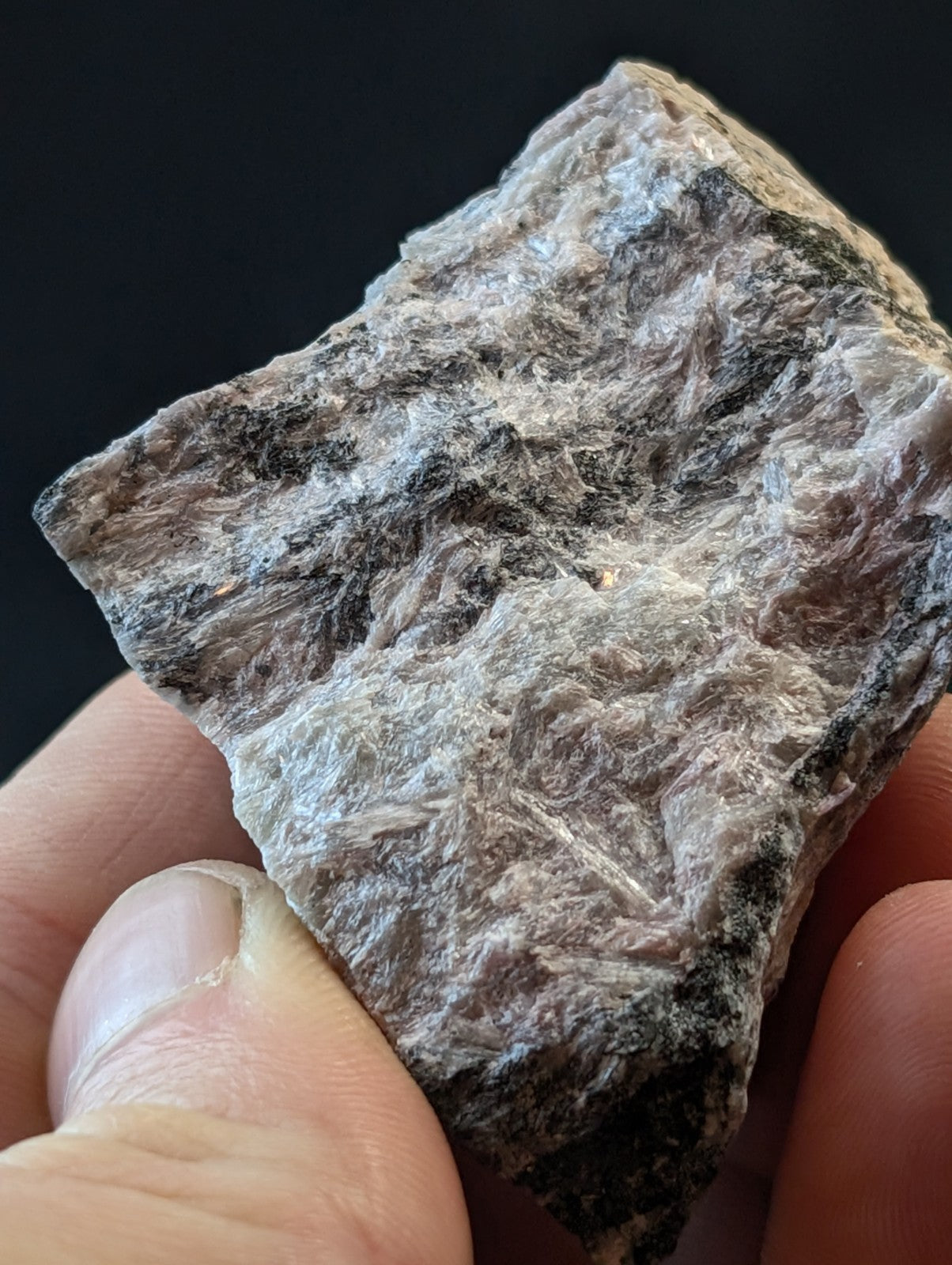 A rough, irregularly shaped mineral specimen with a mottled gray and black surface texture.