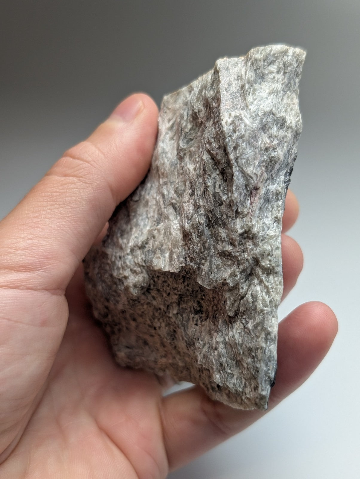 A very rare miserite and wollastonite gray rock with speckled texture and mineral veins from wilson springs arkansas