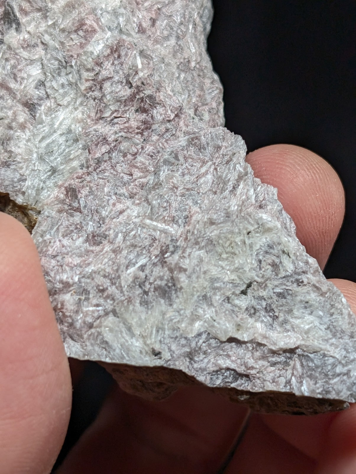 A translucent, crystalline mineral specimen with a rough, jagged surface and subtle grayish-white hues.