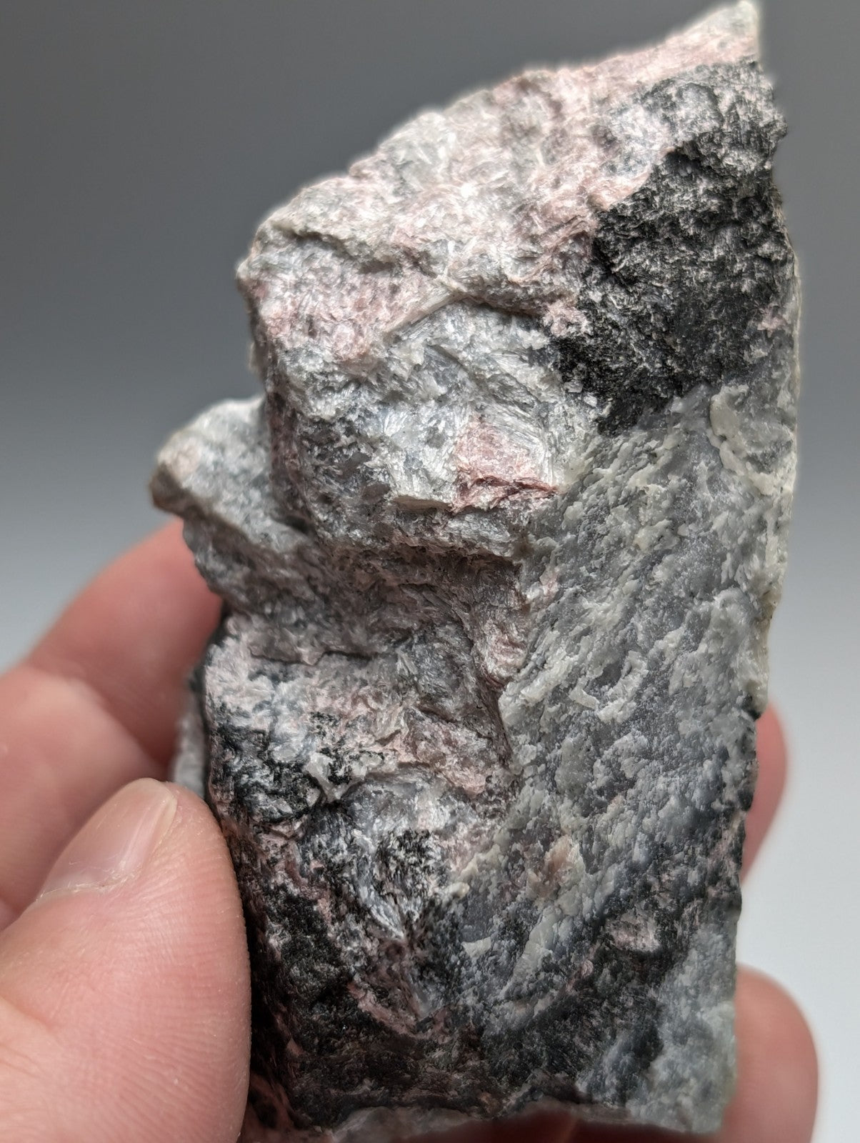 A rugged irregular miserlite and wollastonite rock with gray black and pink hues from Wilson Springs Arkansas