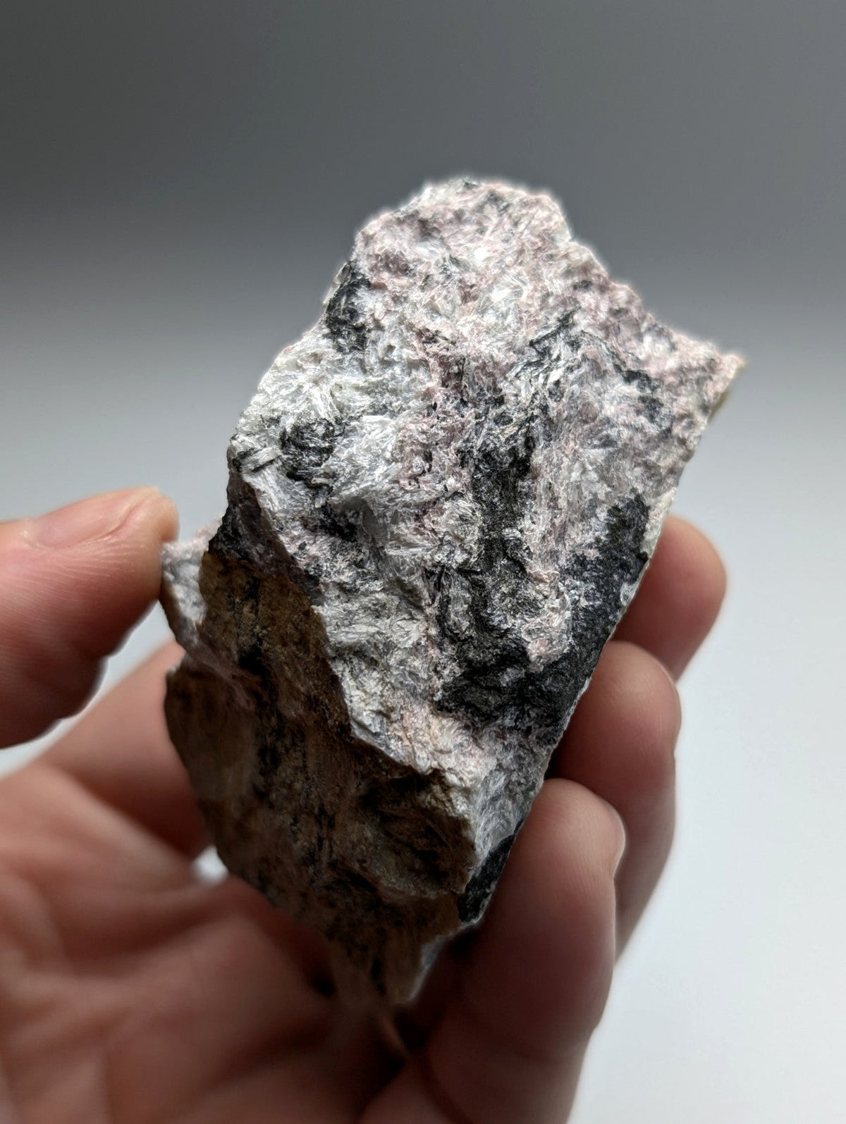 A rough irregularly shaped miserite and wollastonite rock with mottled gray and black surface from wilson springs arkansas