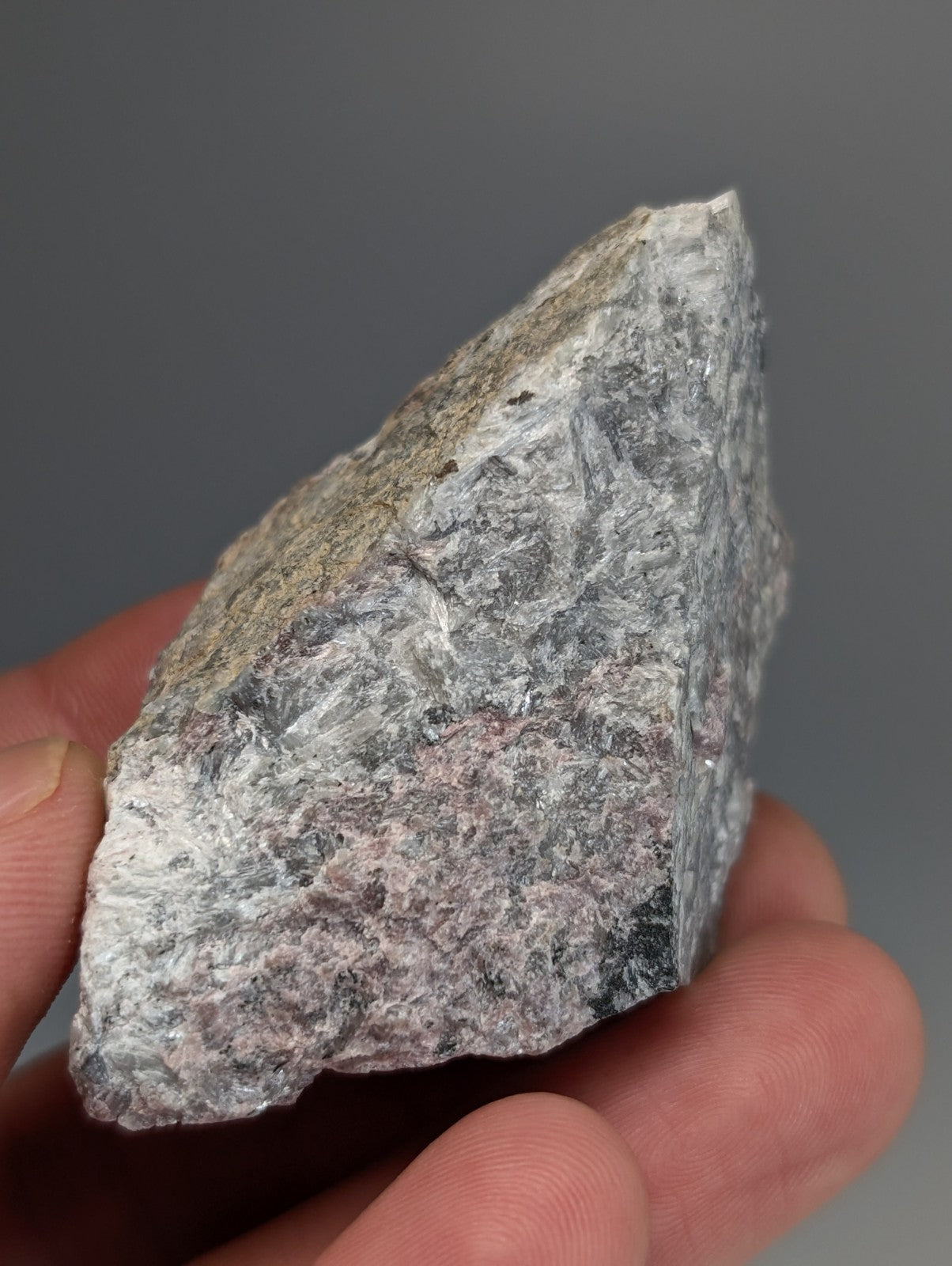 A rough irregular gray miserite and wollastonite rock with pink and black speckles from wilson springs arkansas usa
